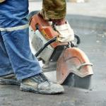 A public works employee cuts into a street to access underground utlities and infrastructure